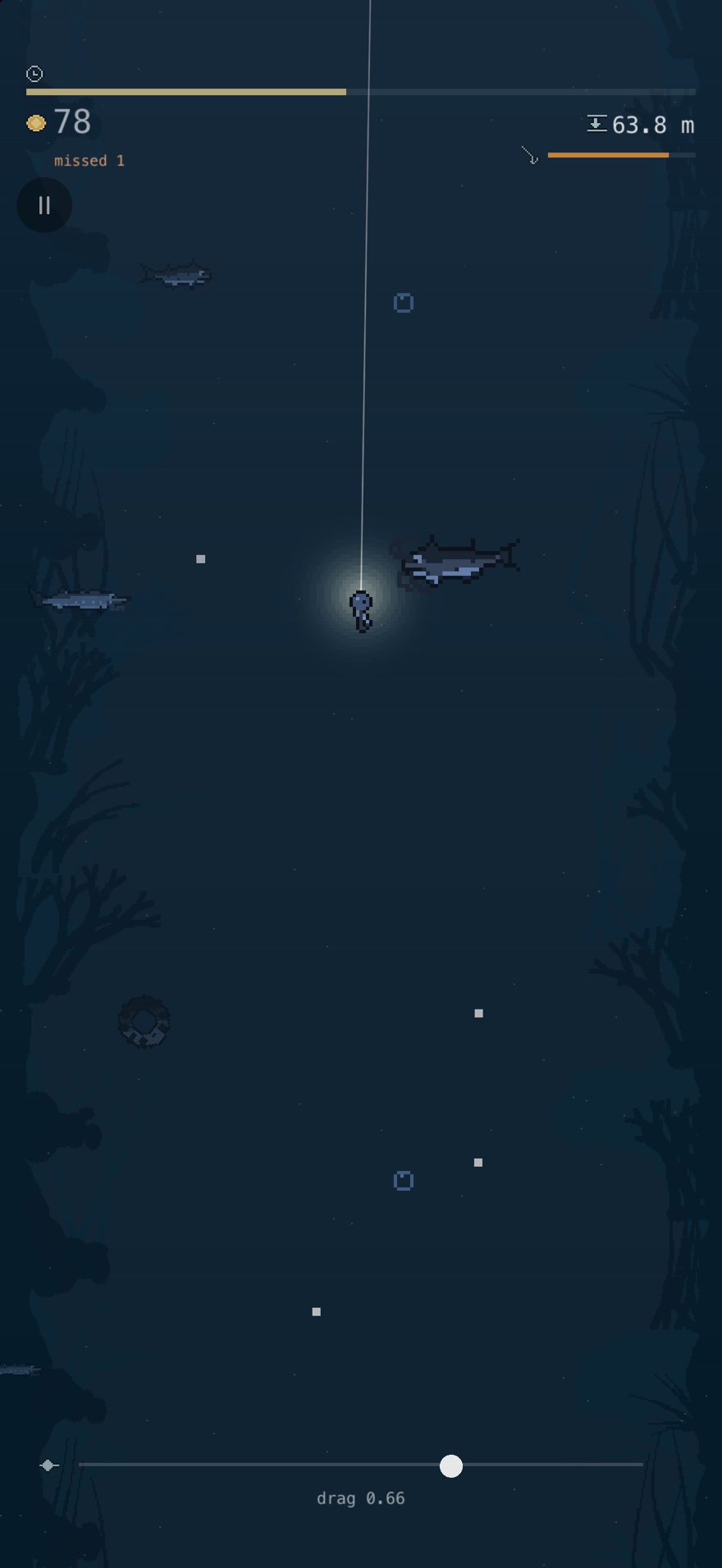 The lure lit by its own lamp at 63.8 metres under the dock, with fish crossing in the dark around it