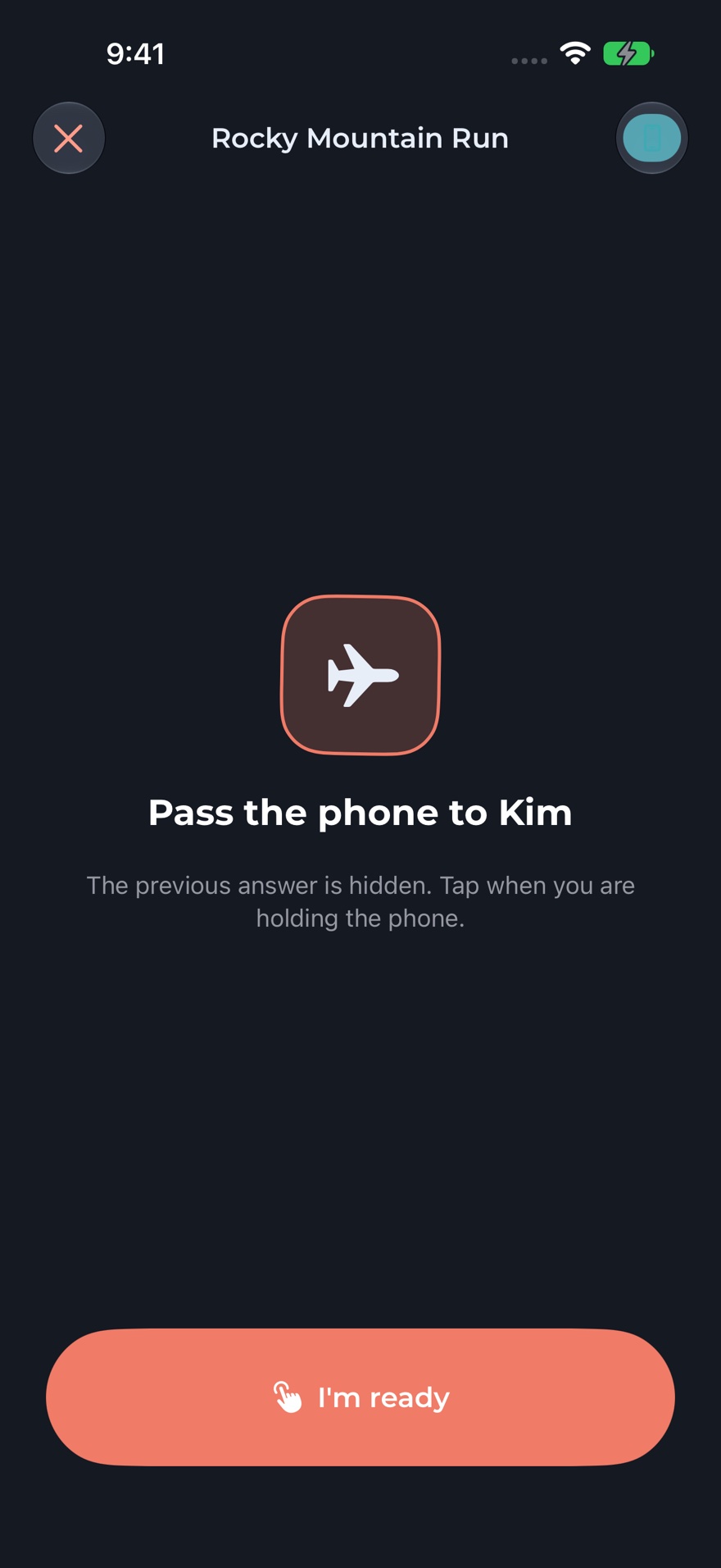 The handoff screen, telling the group to pass the phone to the next player before the previous answer is shown